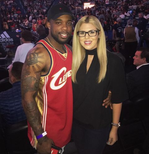 CashNasty in a red kit poses a picture with his girlfriend.